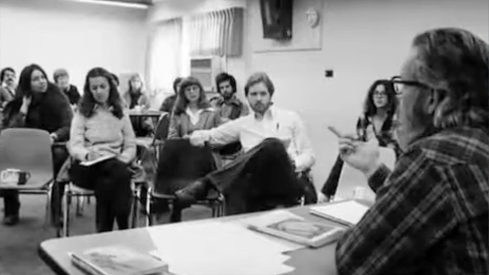 B&W photo of GSPP instructor addressing class of students