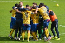 Soccer team gathering in a huddle with their arms linked