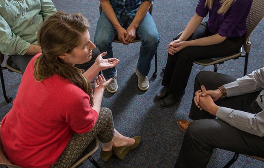 five people sit in a circle during a group therapy session