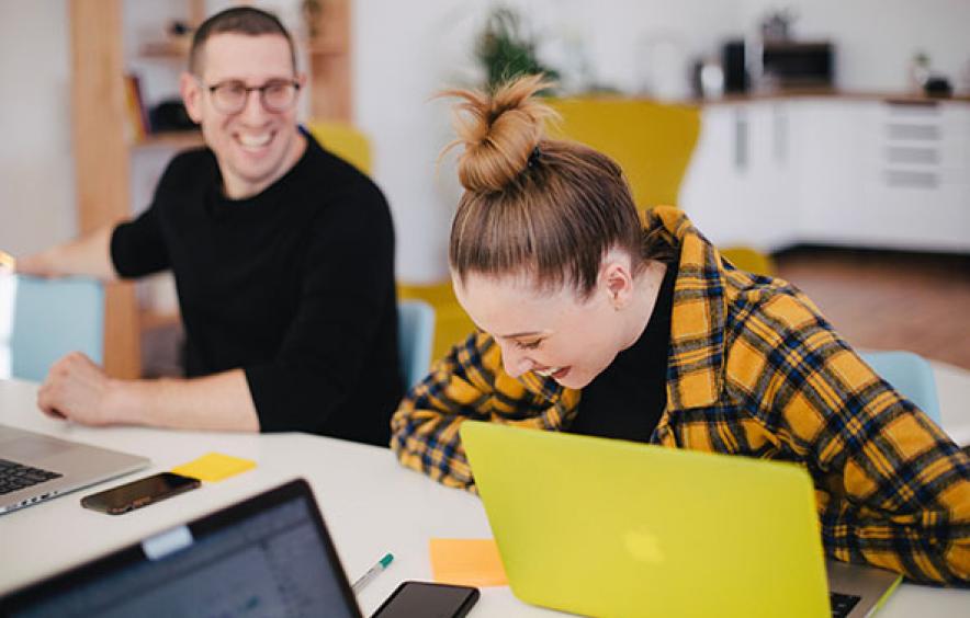 students laughing with laptop