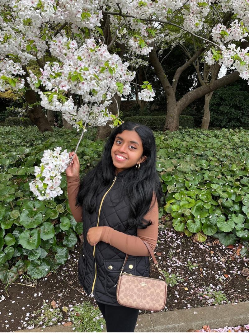 Young woman poses with cherry blossoms